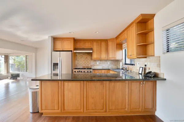 a kitchen with kitchen island granite countertop a sink cabinets and wooden floor