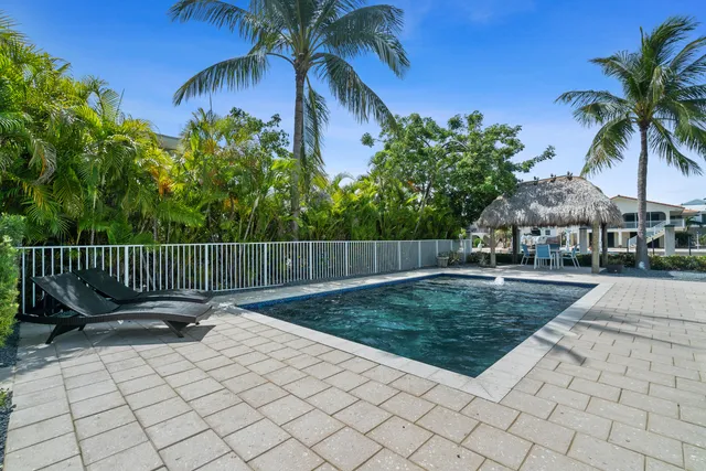 a living room with furniture a large window a flat screen tv and a potted plant