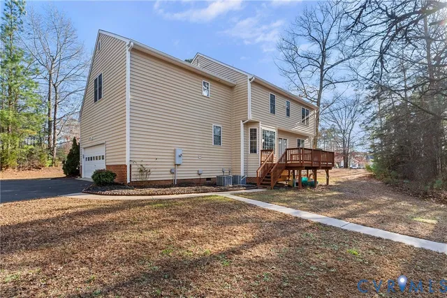 a view of a house with a backyard and wooden deck