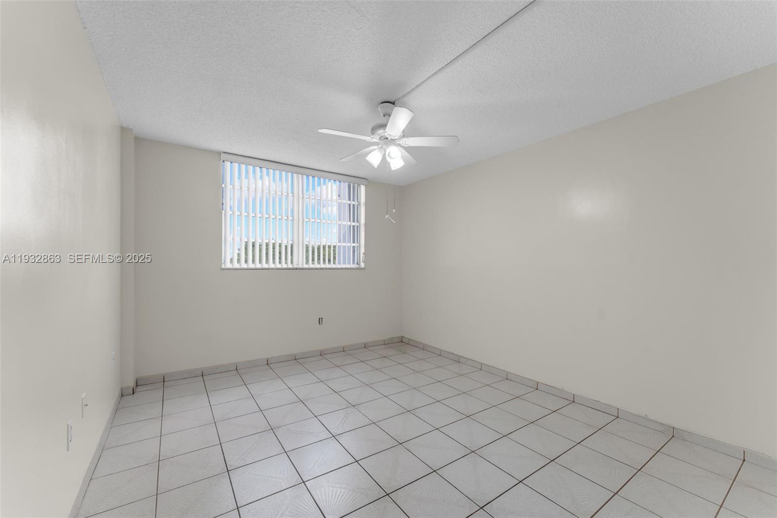 14180 Southwest 84th Street, Unit 508G Miami, FL 33183 - Photo 13 of 32 an empty room with windows and ceiling fan