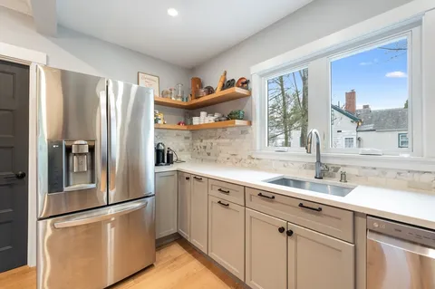 a kitchen with a refrigerator sink and cabinets