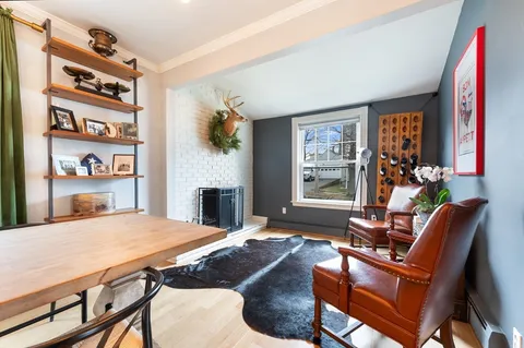 a living room with furniture a fireplace and a large window