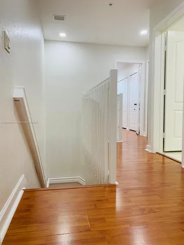 a view of empty room with wooden floor