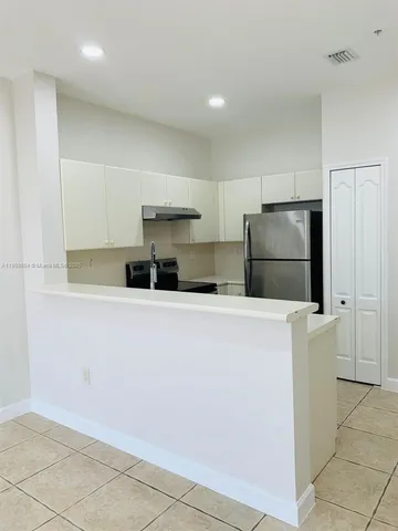 a kitchen with cabinets and white stainless steel appliances