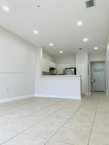 a view of kitchen with kitchen island microwave and cabinets
