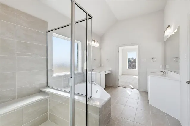 a bathroom with a tub sink shower and mirror