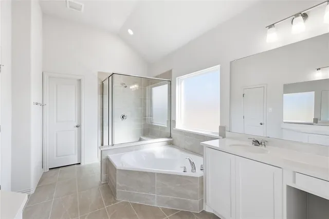 a spacious bathroom with a tub shower sink and mirror
