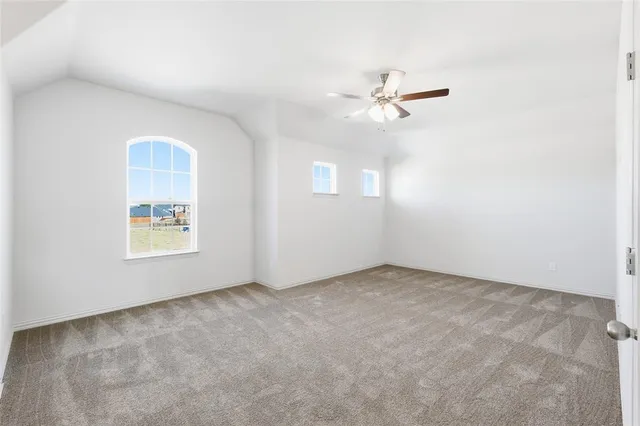 an empty room with fan and windows