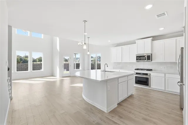 a view of a field of grass and tall trees