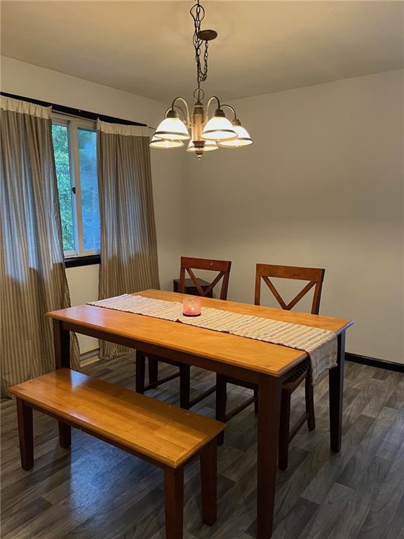 145 Coffman Road Acme, PA 15610 - Photo 5 of 37 a dining room with wooden floor a chandelier a wooden table and chairs