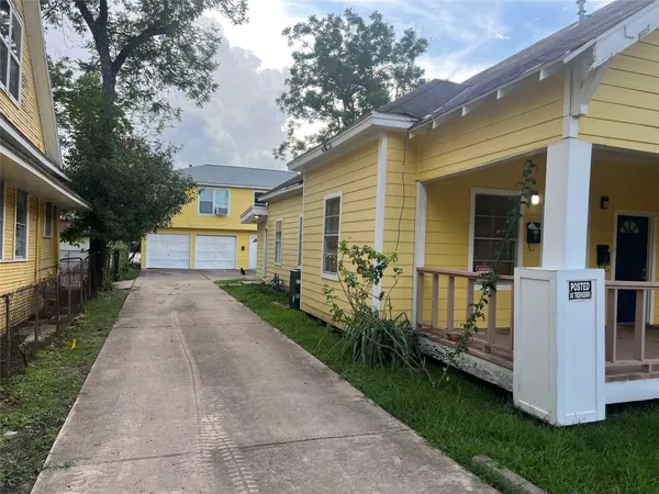 a view of house with a yard and potted plants