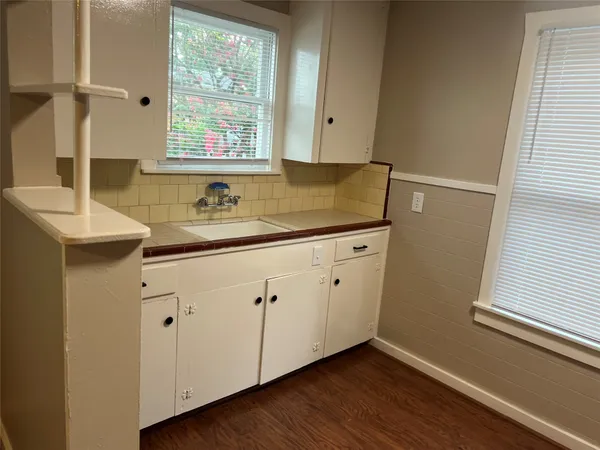 a view with cabinets a window and wooden floor