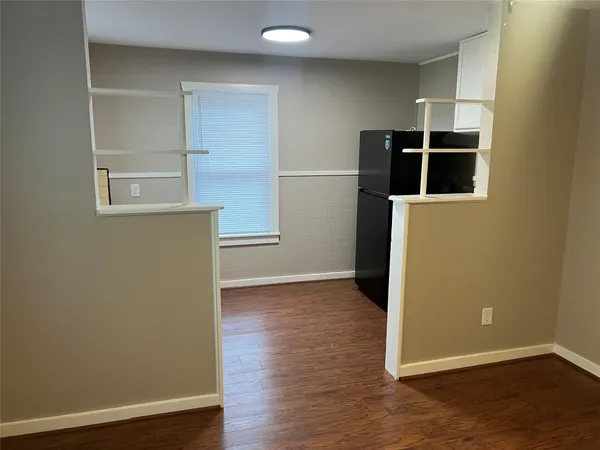 an empty room with wooden floor closet and windows