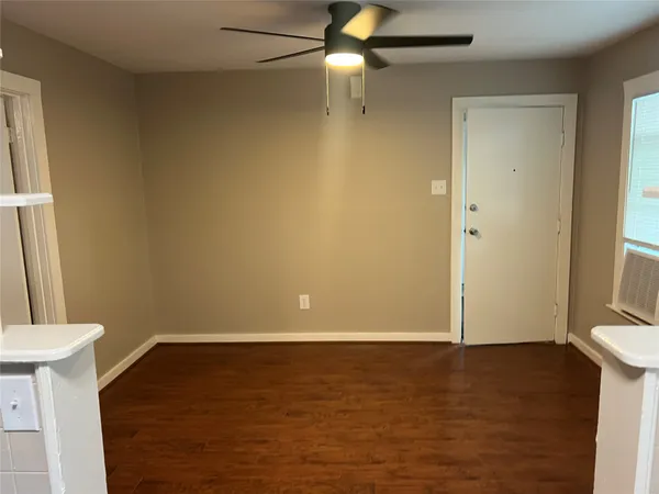 a view of small space with wooden floor and fan