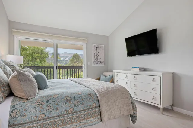 a bedroom with a large bed and a flat screen tv