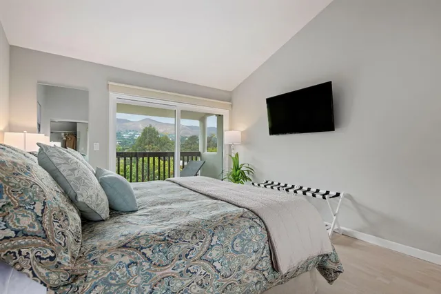 a bedroom with a large bed and a flat screen tv