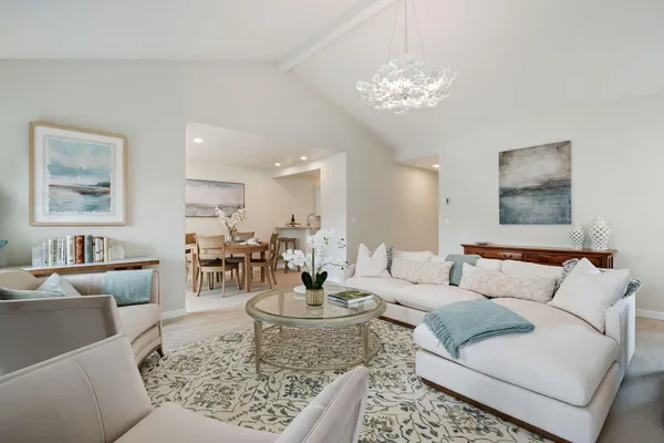 a living room with furniture and a chandelier