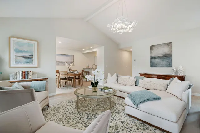 a living room with furniture and a chandelier