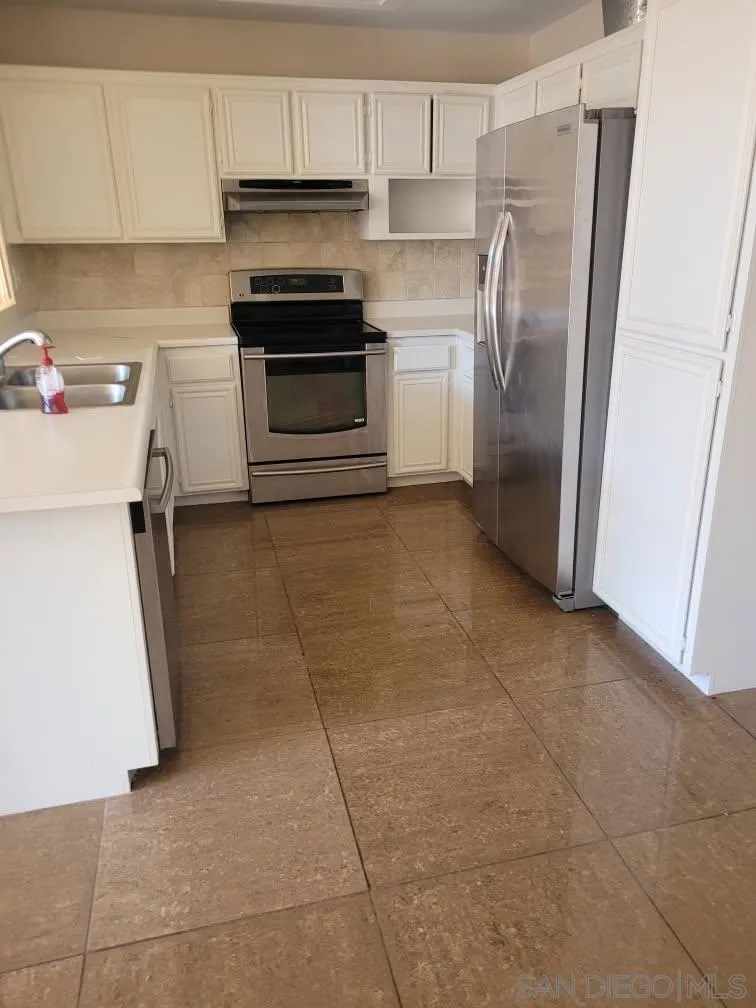 17161 Alva Road, Unit 1424 San Diego, CA 92127 - Photo 2 of 10 a kitchen with a refrigerator sink and cabinets