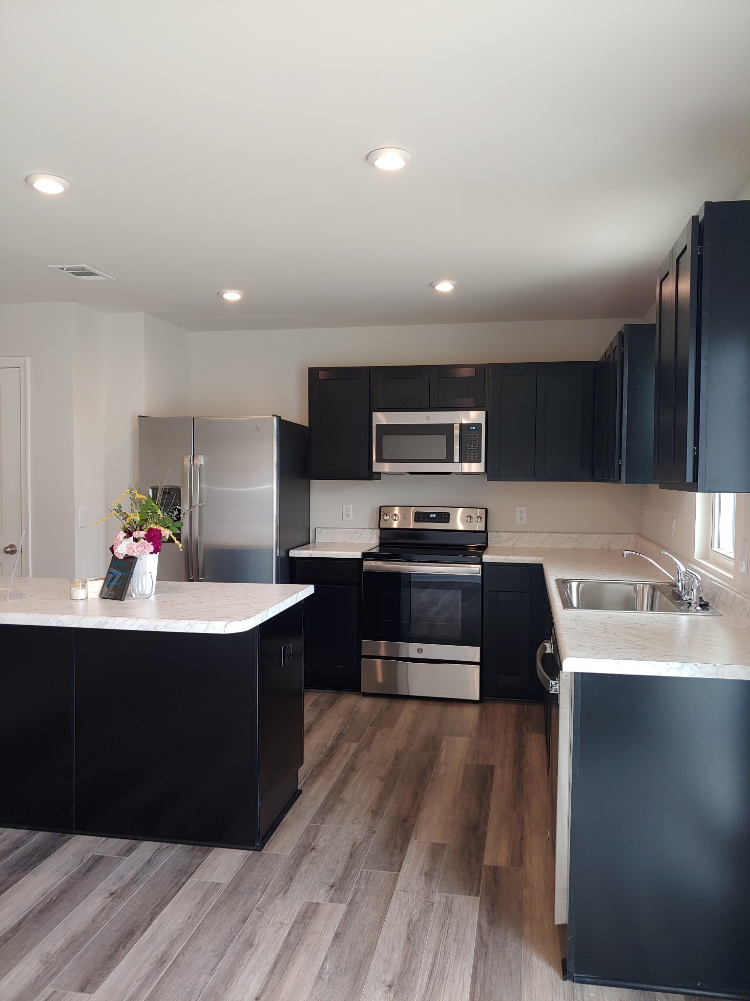 637 Woodall Ridge Drive Lebanon, TN 37090 - Photo 13 of 14 a kitchen with stainless steel appliances kitchen island granite countertop a sink a stove top oven and wooden floors