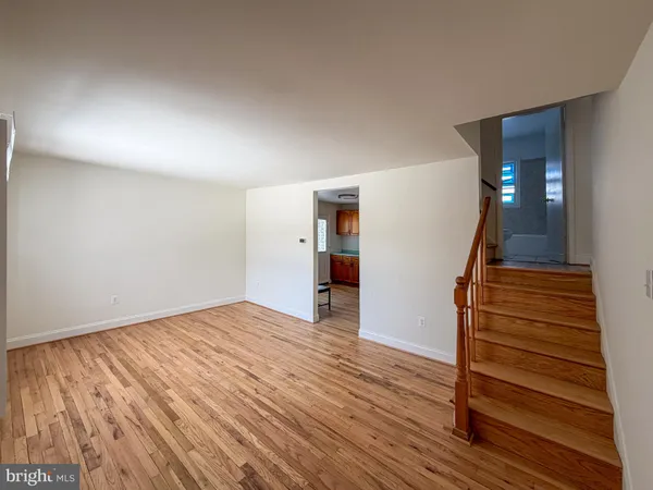 a view of empty room with wooden floor and stairs