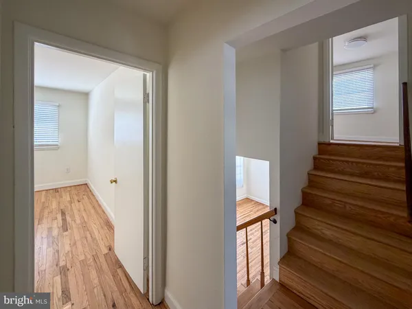 a view of a hallway with wooden floor and entryway