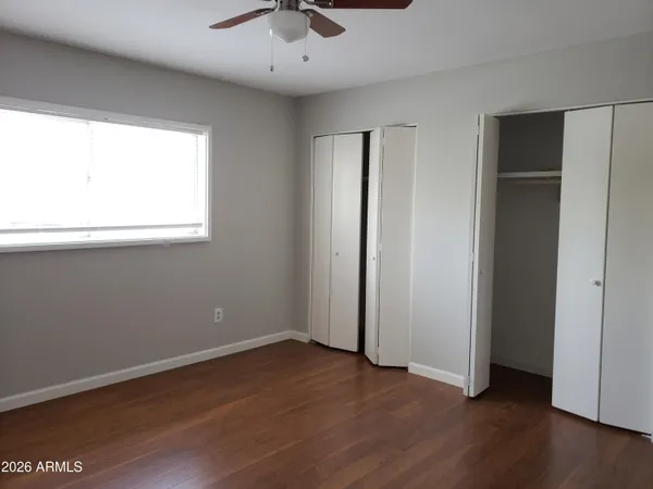 an empty room with wooden floor and a window