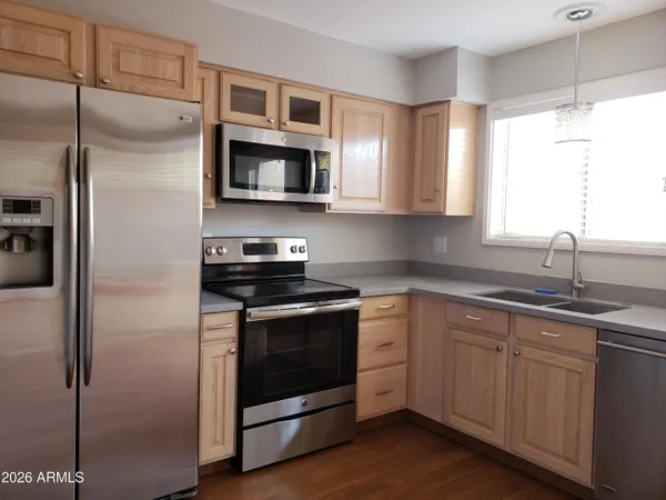 a kitchen with stainless steel appliances granite countertop a stove a sink and a refrigerator