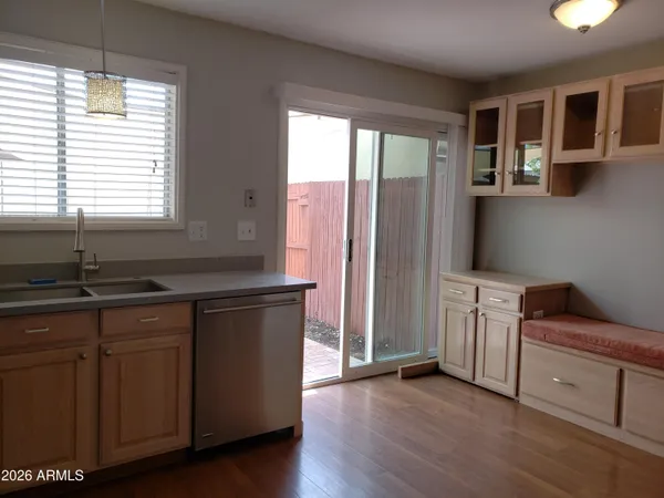 a kitchen with stainless steel appliances granite countertop a sink cabinets and wooden floor
