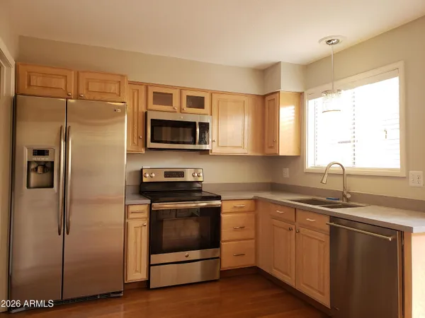 a kitchen with a sink stainless steel appliances and window