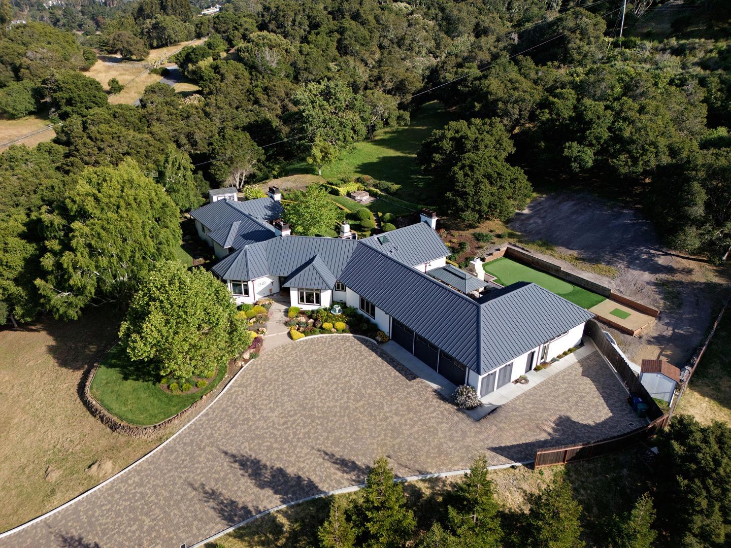 an aerial view of a house with a yard basket ball court and outdoor seating
