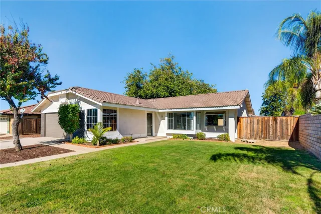 a front view of house with a garden and patio