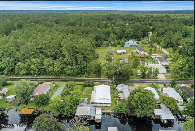 an aerial view of residential houses with outdoor space and trees