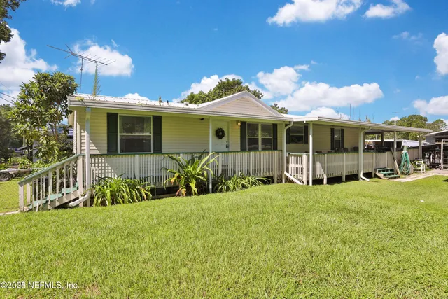 a view of a house with a yard and fence