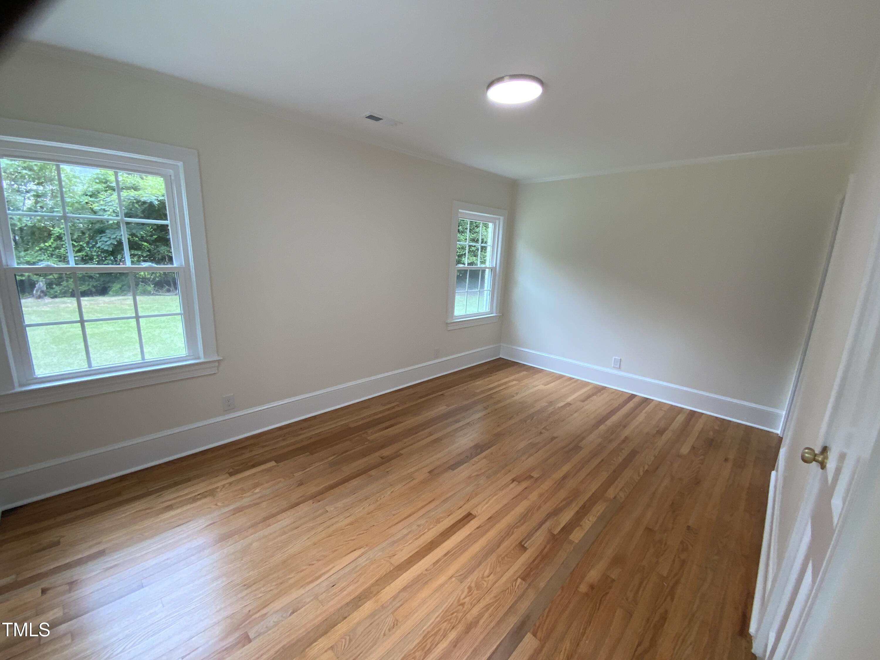 1101 West Divine Street Dunn, NC 28334 - Photo 11 of 36 wooden floor in an empty room with a window