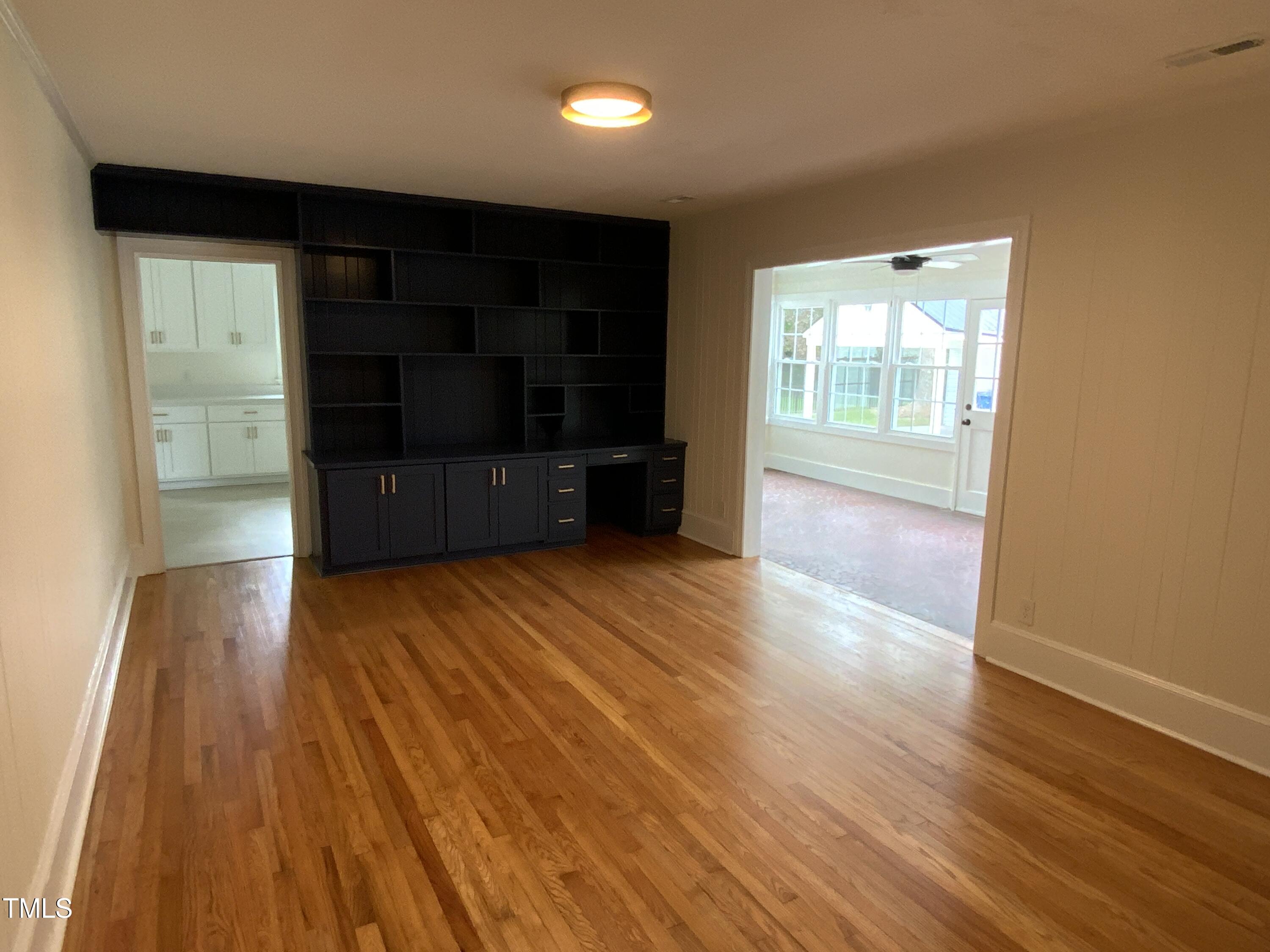 1101 West Divine Street Dunn, NC 28334 - Photo 12 of 36 a view of empty room with wooden floor and fan