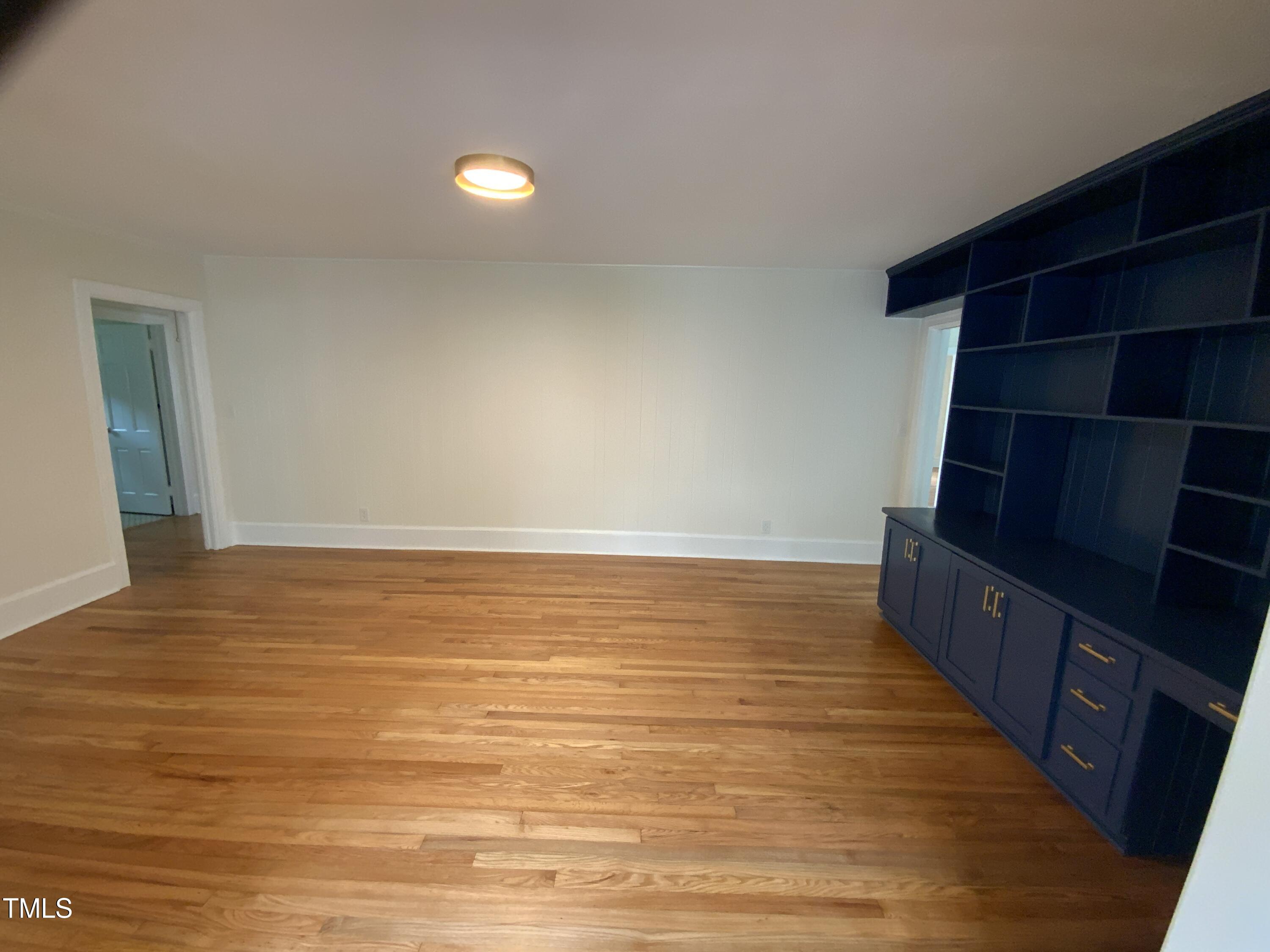 1101 West Divine Street Dunn, NC 28334 - Photo 14 of 36 a view of an empty room with wooden floor and staircase