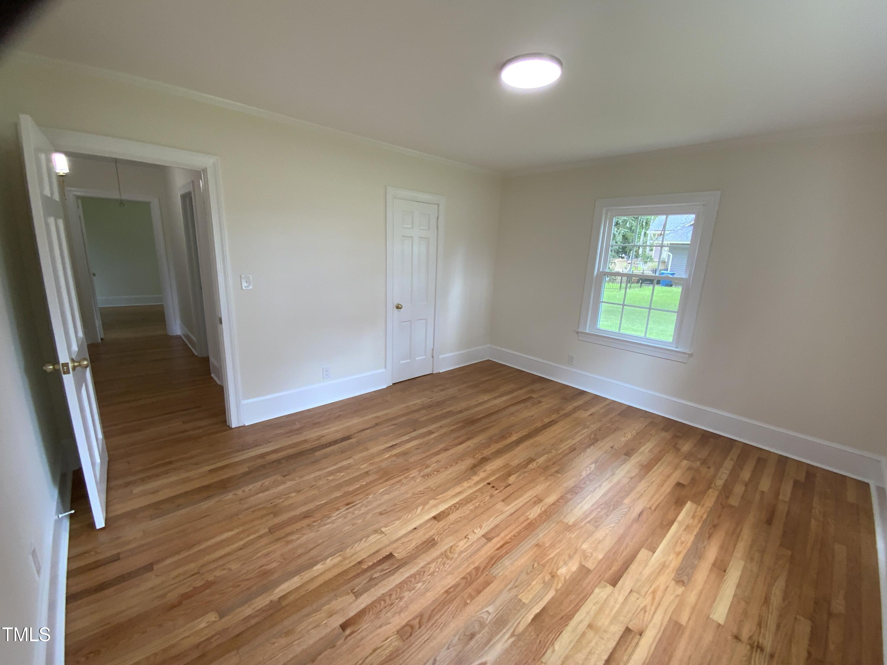1101 West Divine Street Dunn, NC 28334 - Photo 15 of 36 an empty room with wooden floor and windows