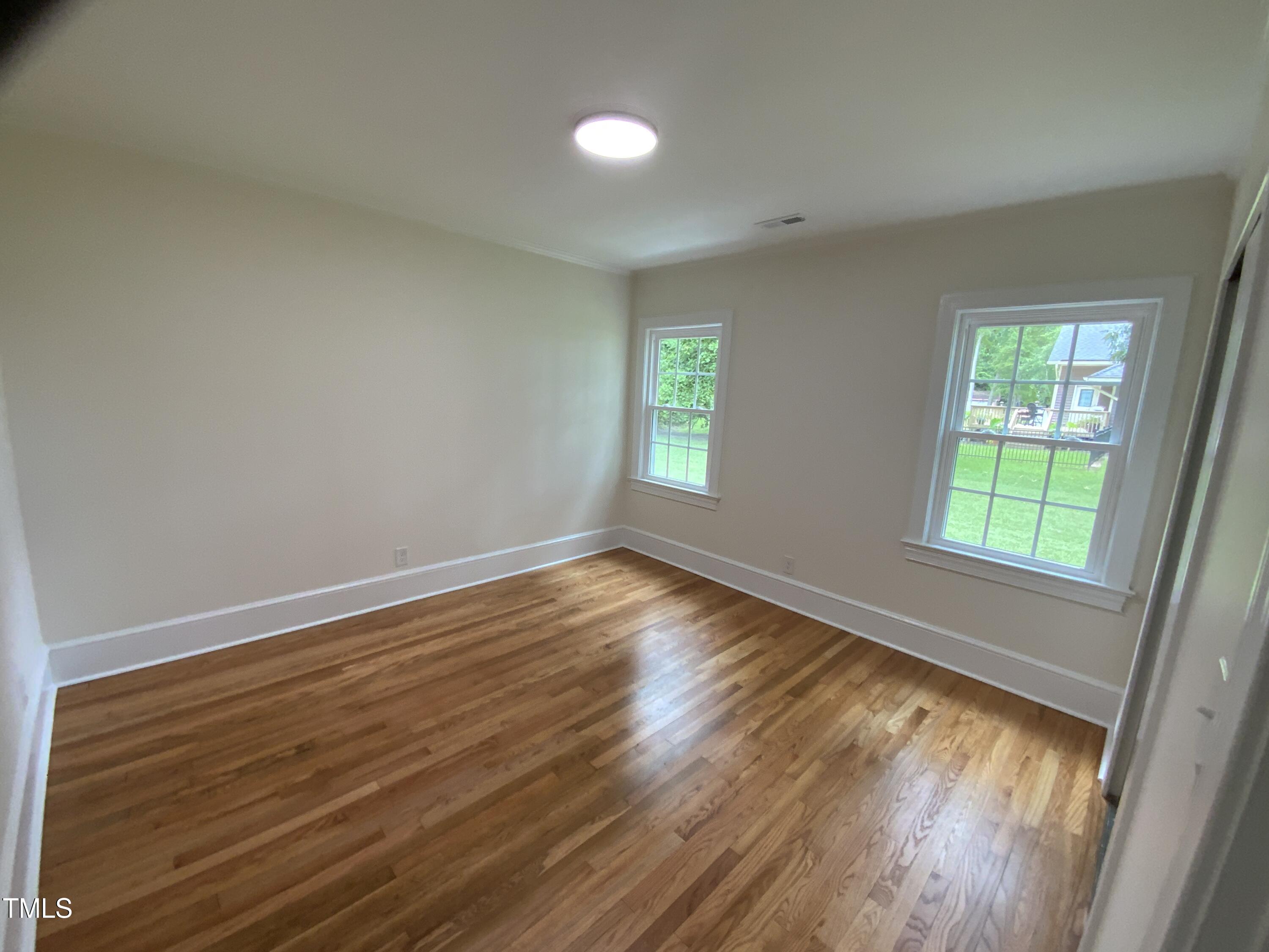 1101 West Divine Street Dunn, NC 28334 - Photo 16 of 36 an empty room with wooden floor and windows