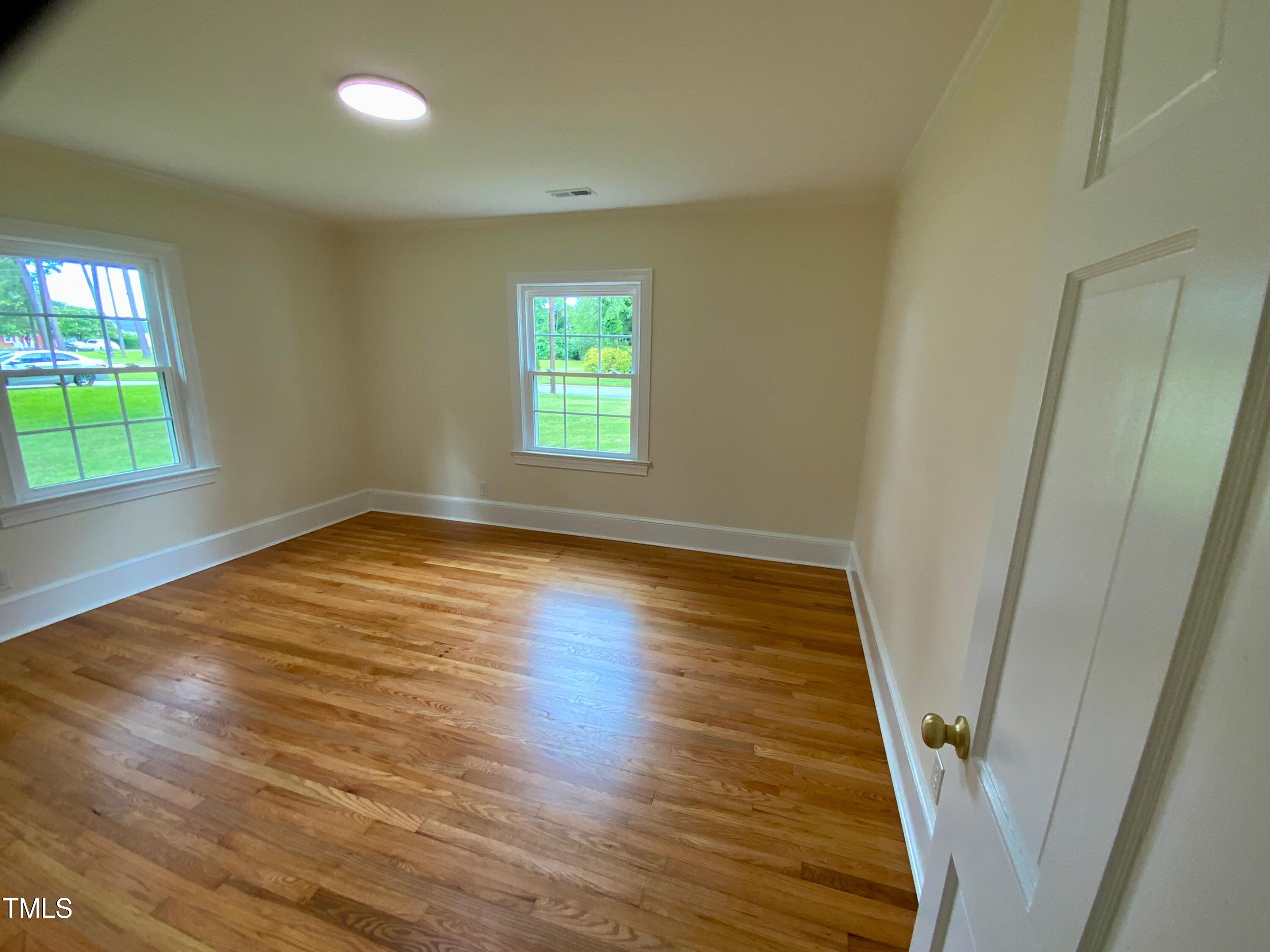 1101 West Divine Street Dunn, NC 28334 - Photo 20 of 36 wooden floor in an empty room with a window