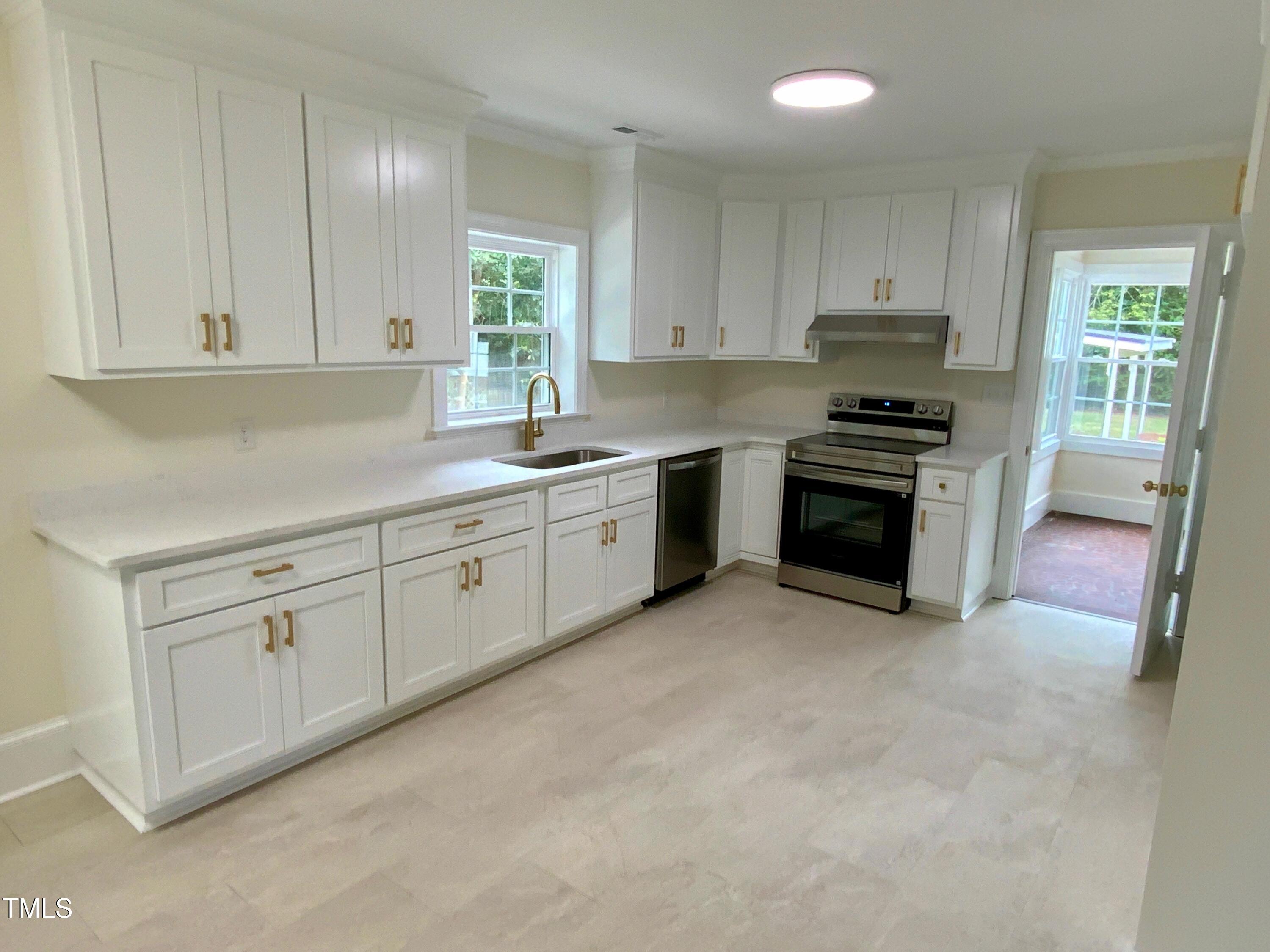 1101 West Divine Street Dunn, NC 28334 - Photo 2 of 36 a kitchen with stainless steel appliances granite countertop a stove a sink and a refrigerator