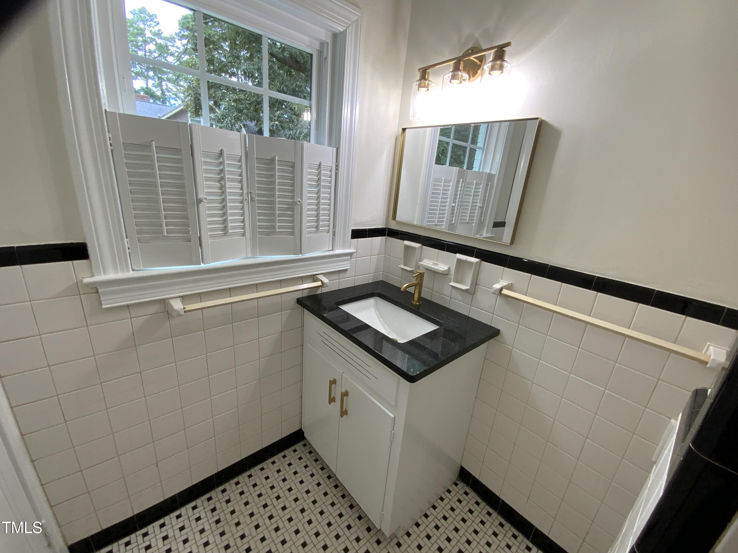 1101 West Divine Street Dunn, NC 28334 - Photo 23 of 36 a bathroom with a sink and a mirror