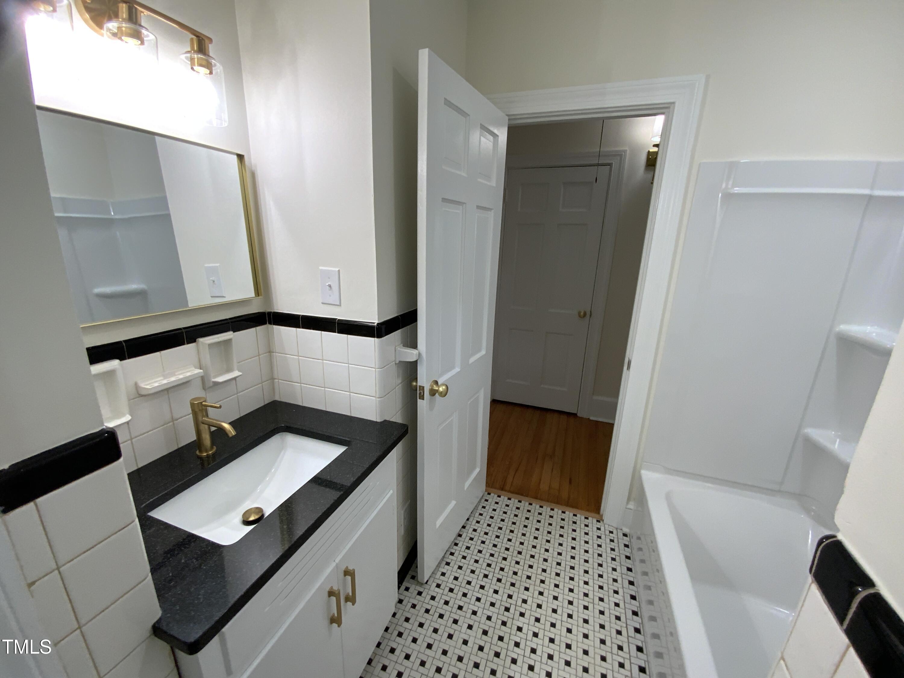 1101 West Divine Street Dunn, NC 28334 - Photo 24 of 36 a view of a hallway with wooden floor and a bathroom