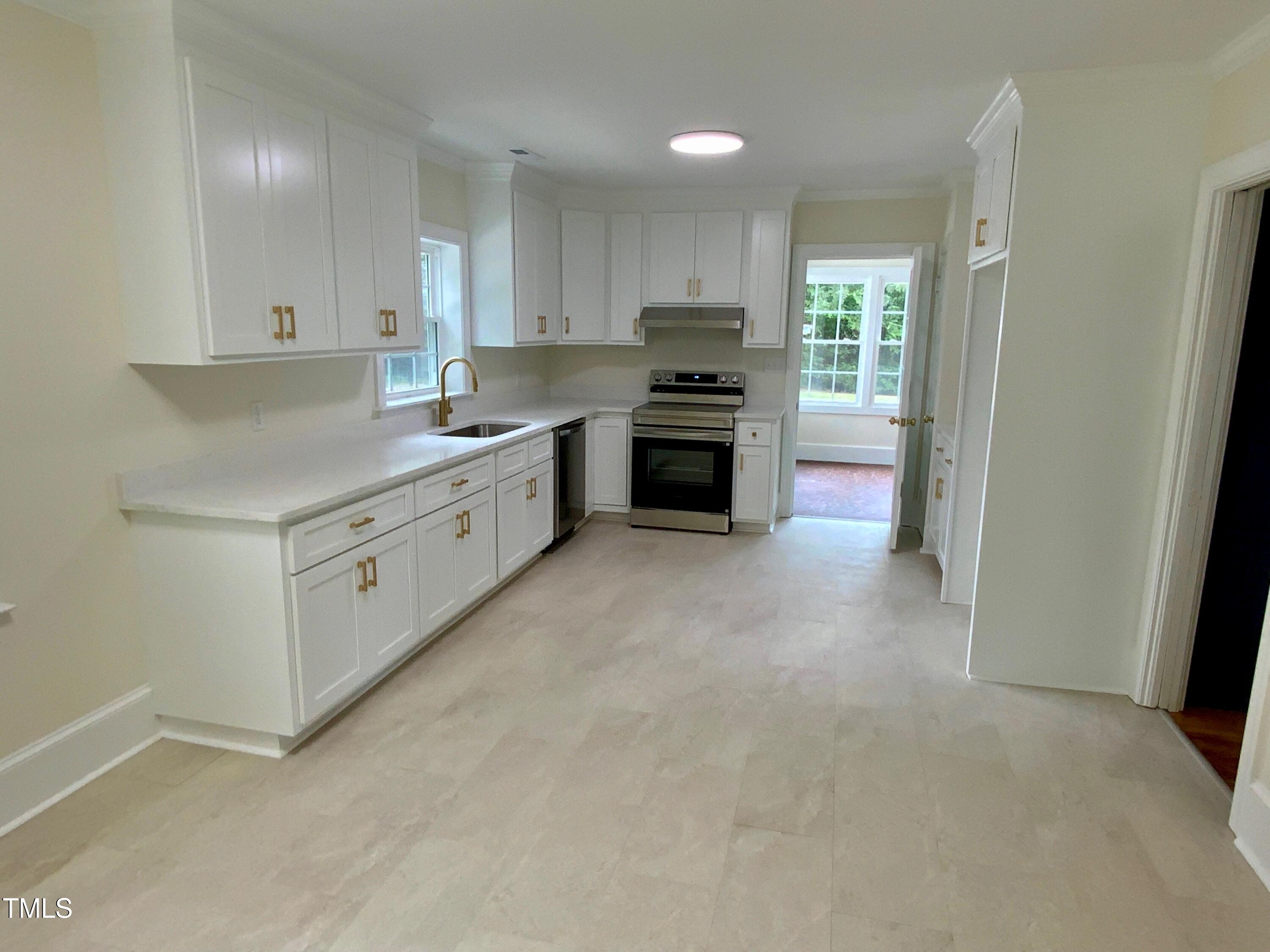 1101 West Divine Street Dunn, NC 28334 - Photo 3 of 36 a kitchen with granite countertop white cabinets and stainless steel appliances