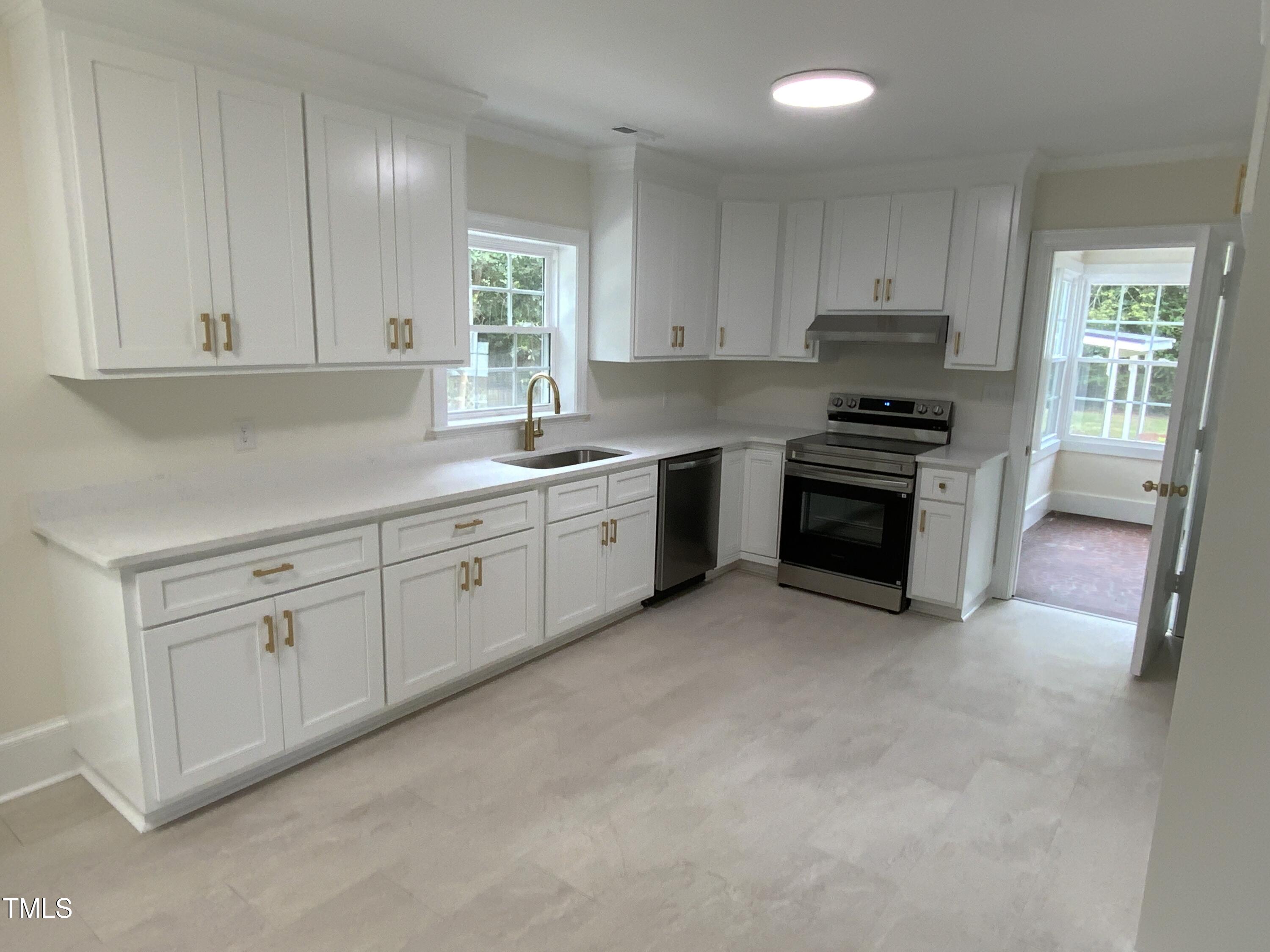 1101 West Divine Street Dunn, NC 28334 - Photo 6 of 36 a kitchen with stainless steel appliances granite countertop a stove a sink and a refrigerator