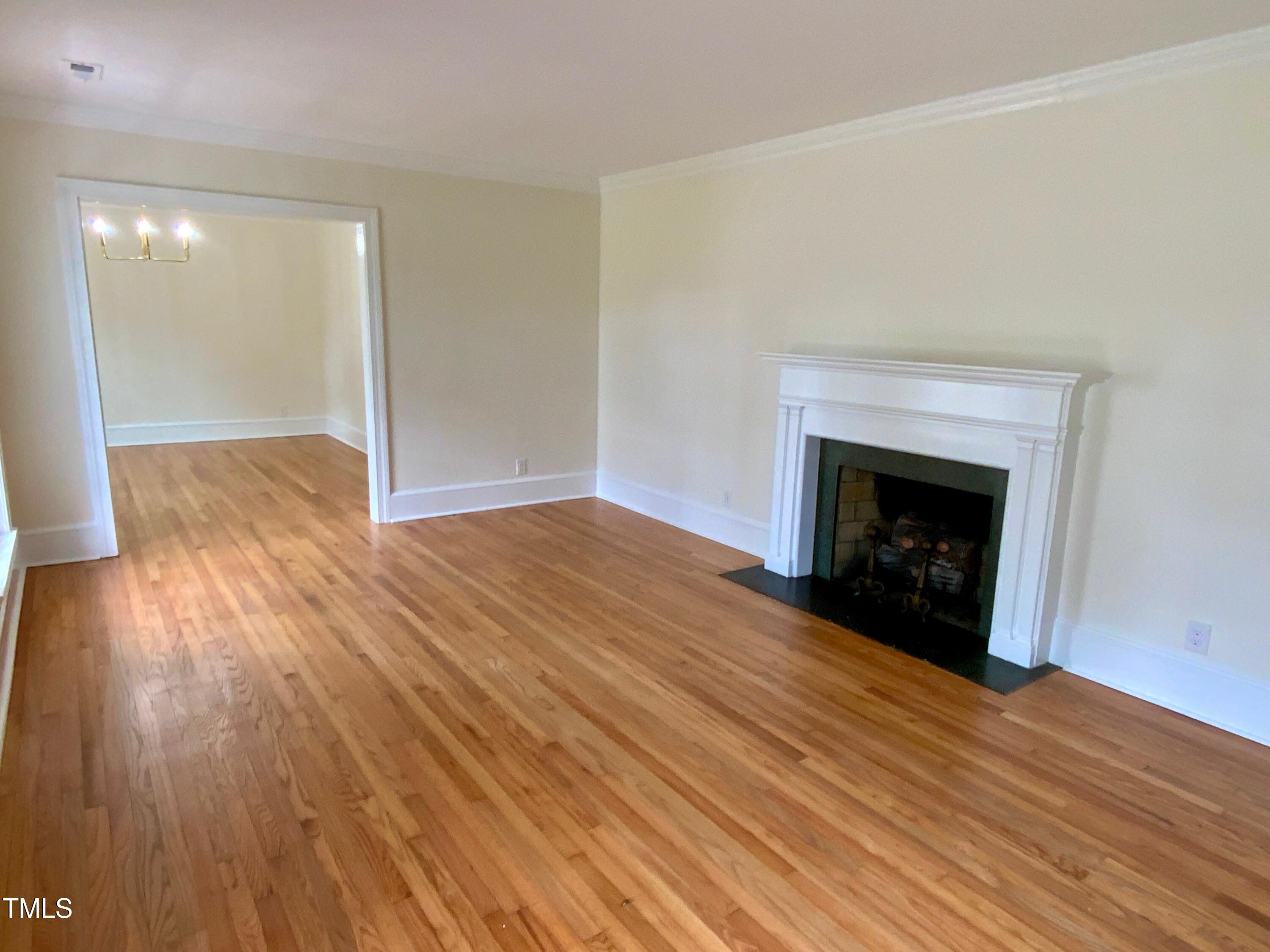 1101 West Divine Street Dunn, NC 28334 - Photo 8 of 36 an empty room with wooden floor and fireplace
