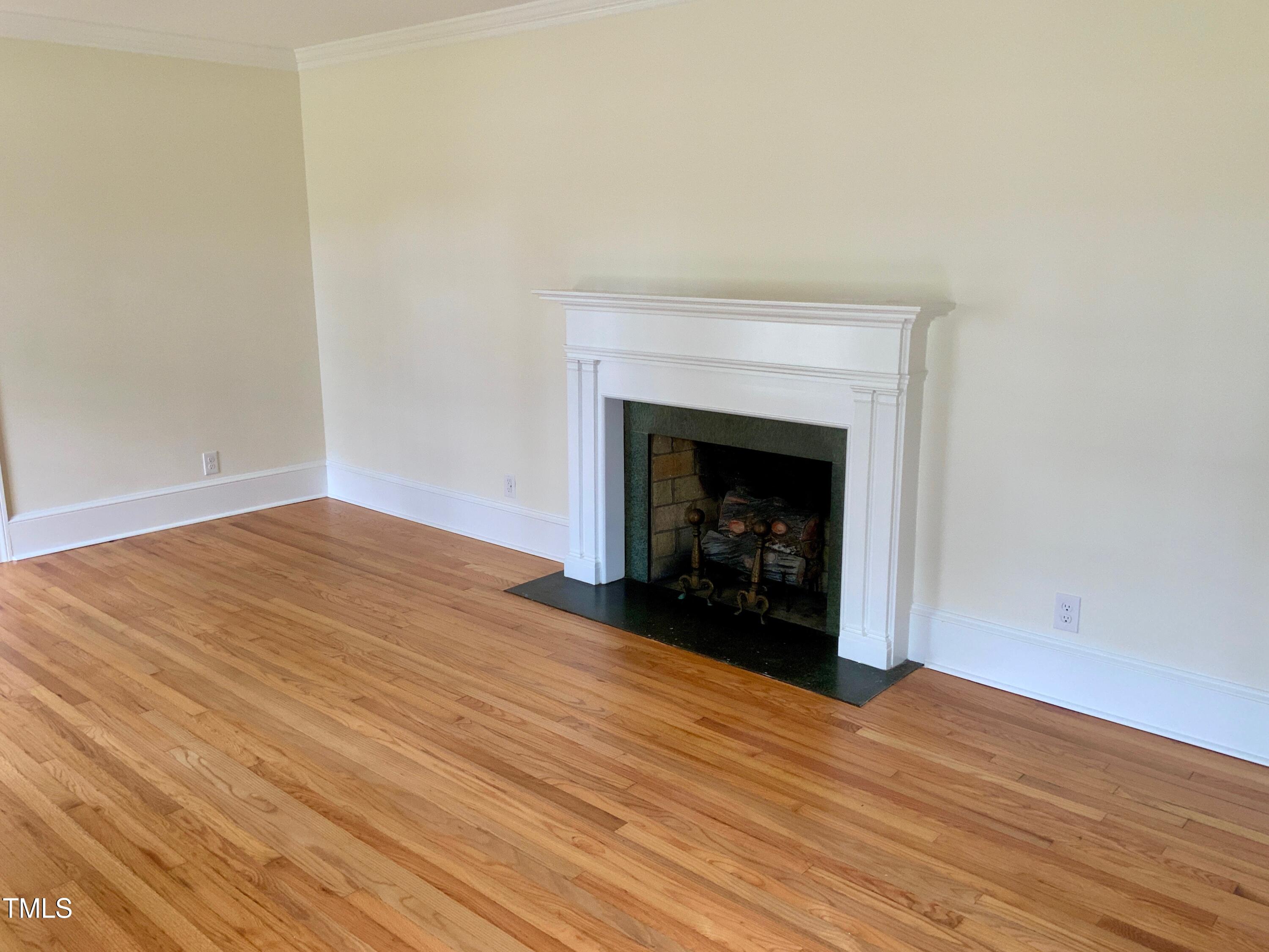 1101 West Divine Street Dunn, NC 28334 - Photo 9 of 36 a view of an empty room with wooden floor fireplace and a window