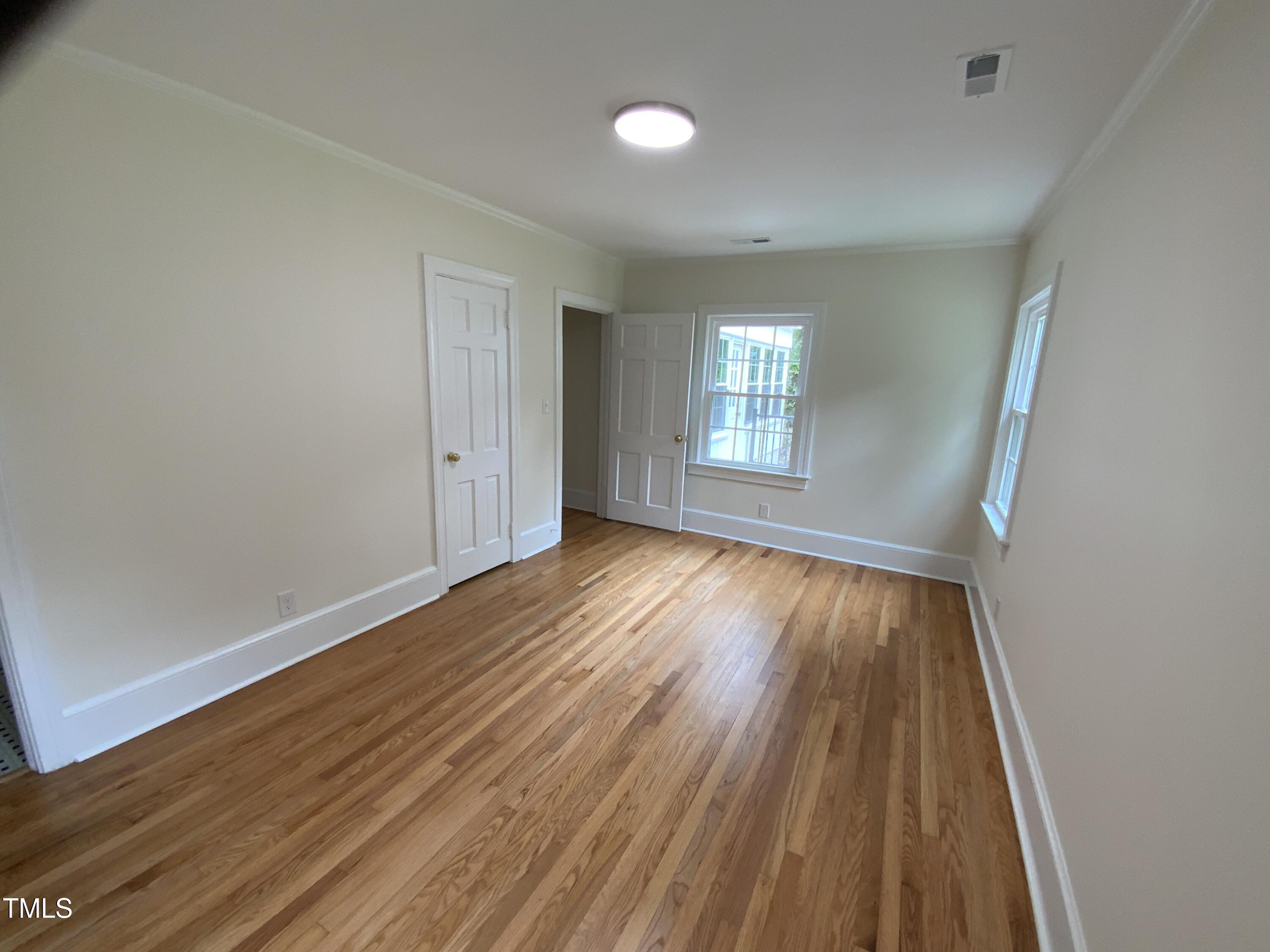 1101 West Divine Street Dunn, NC 28334 - Photo 10 of 36 wooden floor in an empty room with a window