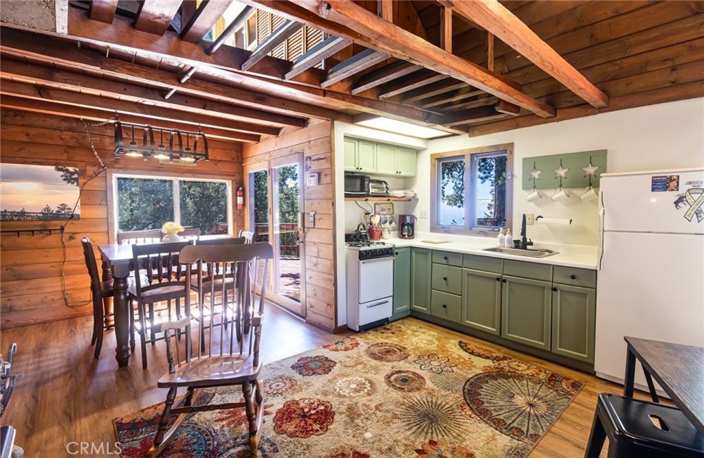 24387 Rocky Point Road Idyllwild, CA 92549 - Photo 24 of 29 a kitchen with sink cabinets and dining table