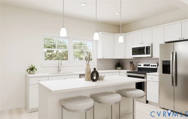 a kitchen with stainless steel appliances a sink a stove a refrigerator cabinets and a window